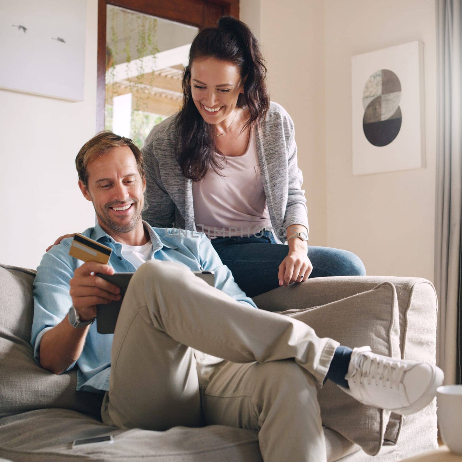 Ive always wanted to get this...an affectionate young couple using a digital tablet and a credit card to shop online at home