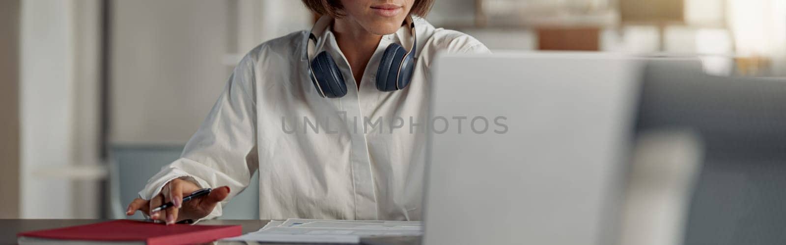 Focused european business woman working laptop and making notes while sitting in modern office by Yaroslav_astakhov