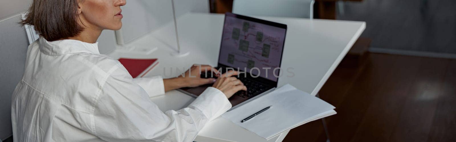 Focused european business woman working laptop while sitting in cozy cafe and looking away by Yaroslav_astakhov