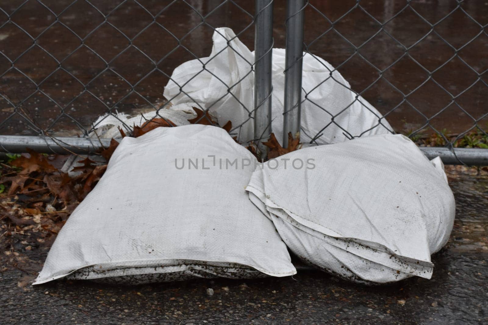 Sandbags Holding A Construction Fence in the Rain. High quality photo
