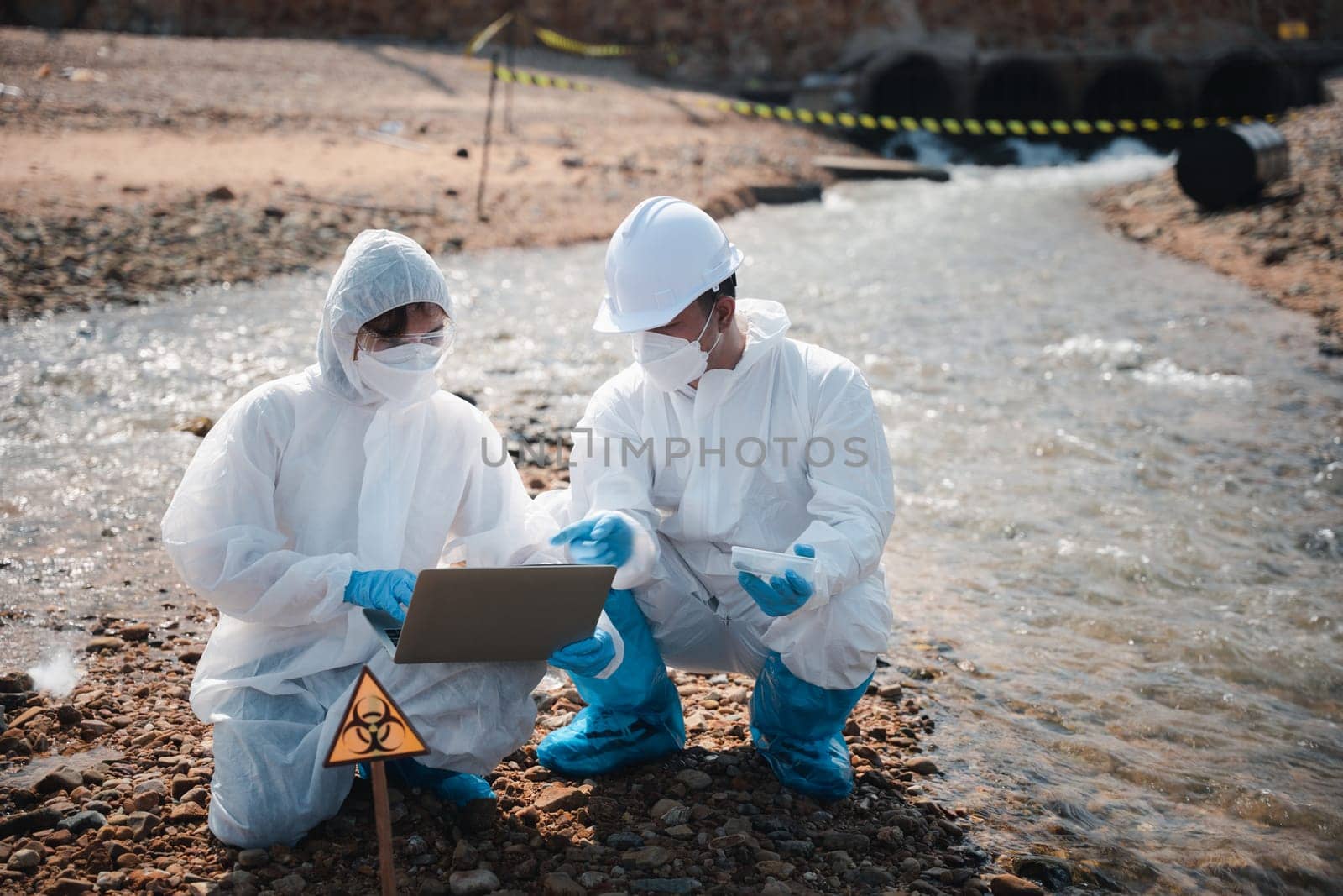 Ecologist sampling taken dead fish to inspaction and save data to laptop computer by Sorapop