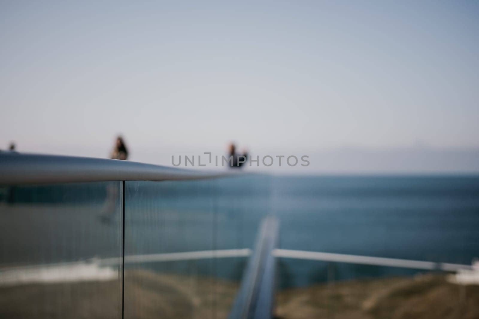 Abstract selective focus glass fence in the seaside park. a popular viewpoint, admiring the natural beauty of the sunset. An observation deck with a figured fence and a lantern. City view. by panophotograph
