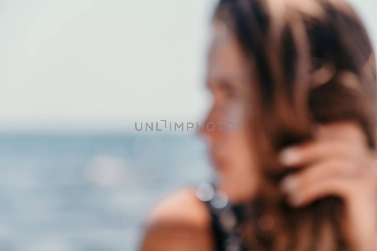 Woman travel sea. Young Happy woman in a long red dress posing on a beach near the sea on background of volcanic rocks, like in Iceland, sharing travel adventure journey