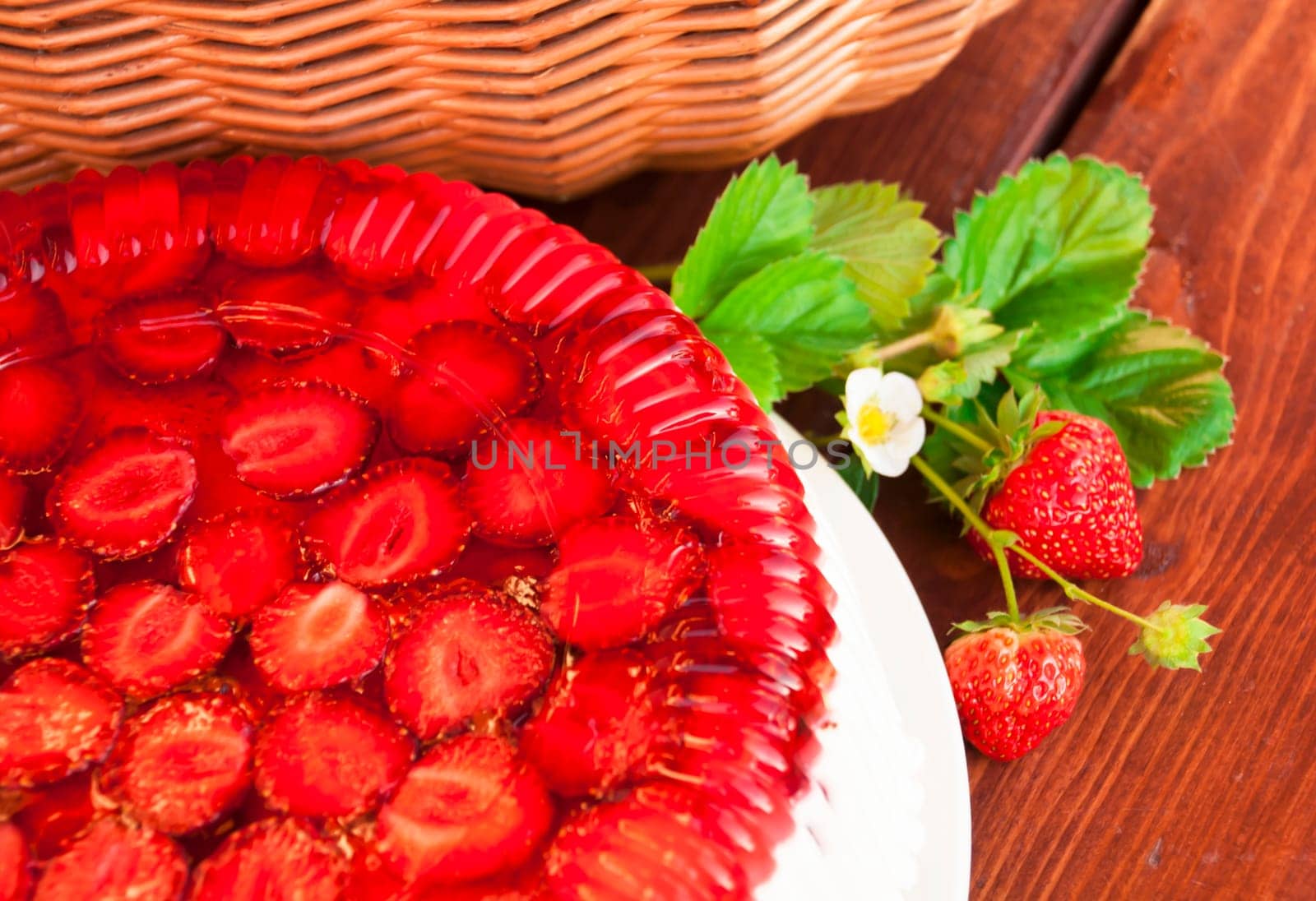 Tart with strawberries and whipped cream decorated with mint leaves. Wooden background. Top view. Near iron