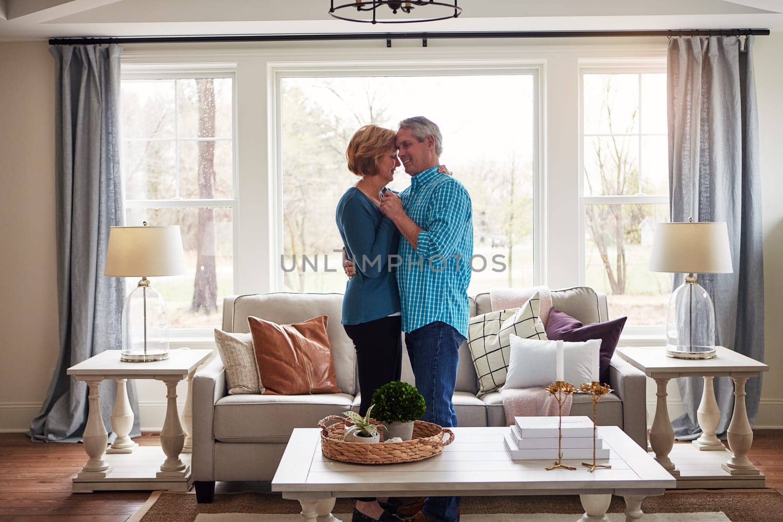 Romance doesnt always need frills and thrills. a happy mature couple dancing together in their living room at home