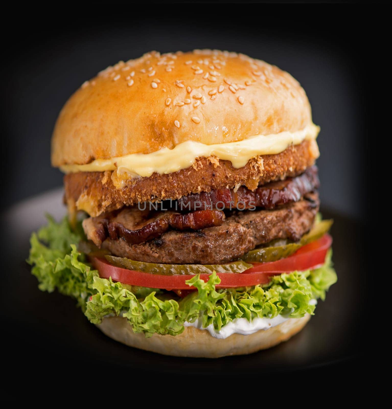 Cheeseburger with beef,tomato, lettuce and onion on wooden table. Copy space