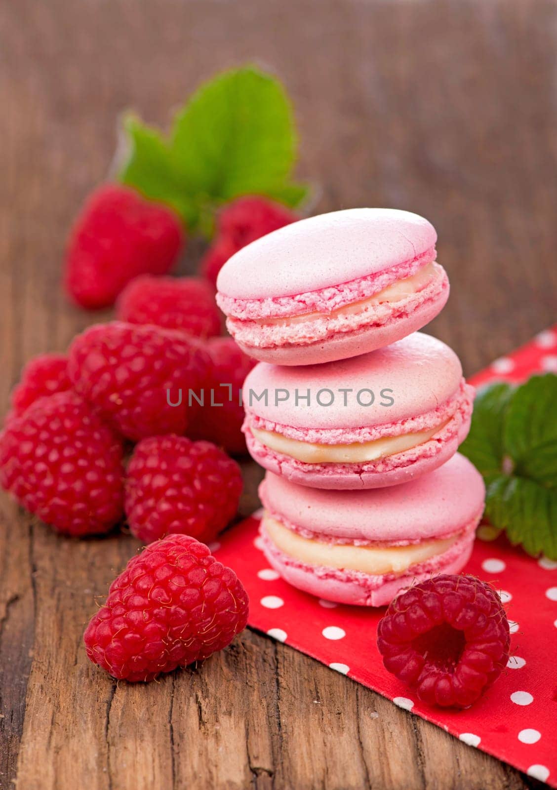 French makarons cake . Pink raspberry macaron cookies on dark wooden boards by aprilphoto