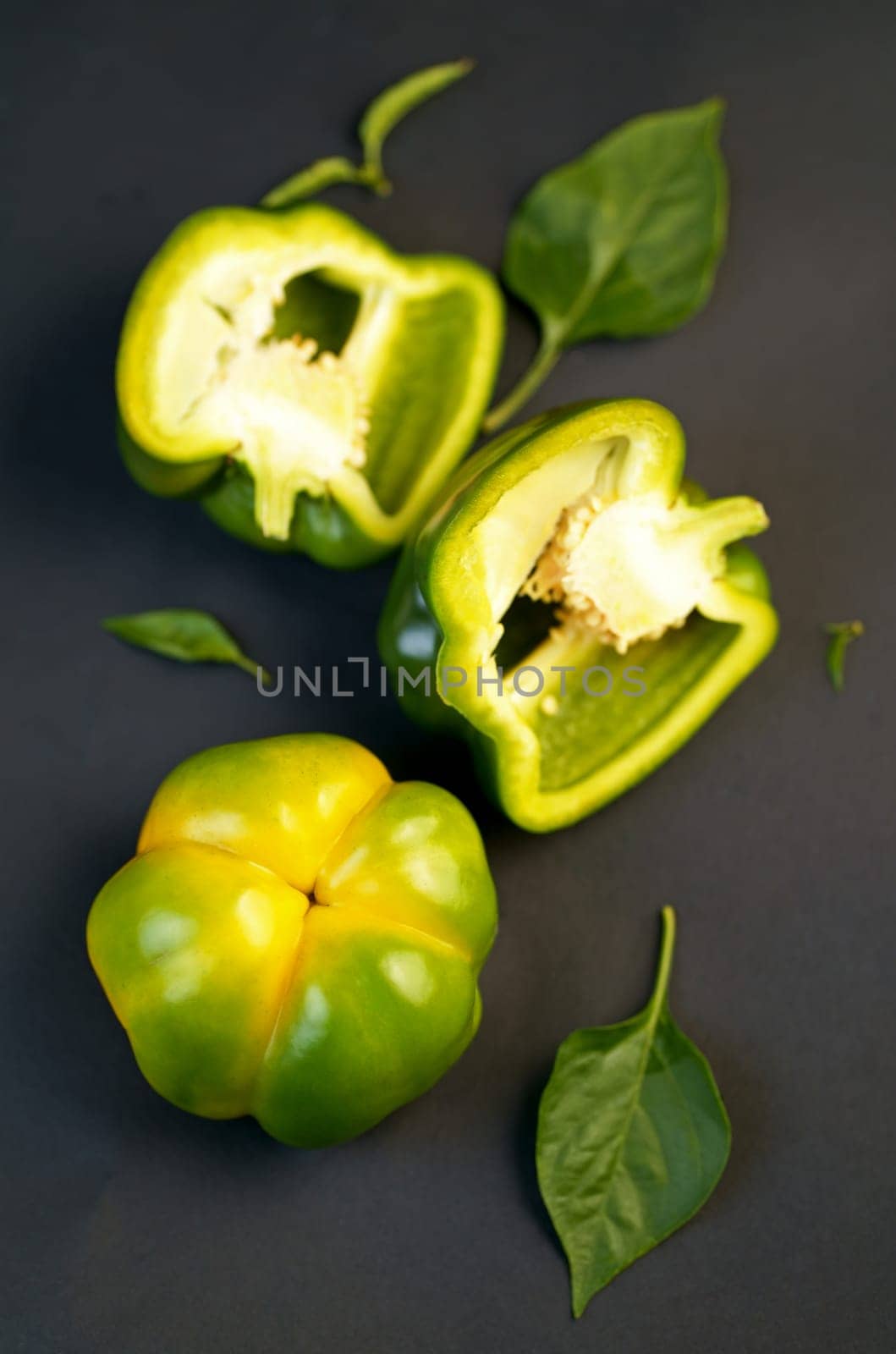 Raw sliced green bulgarian pepper on black background
