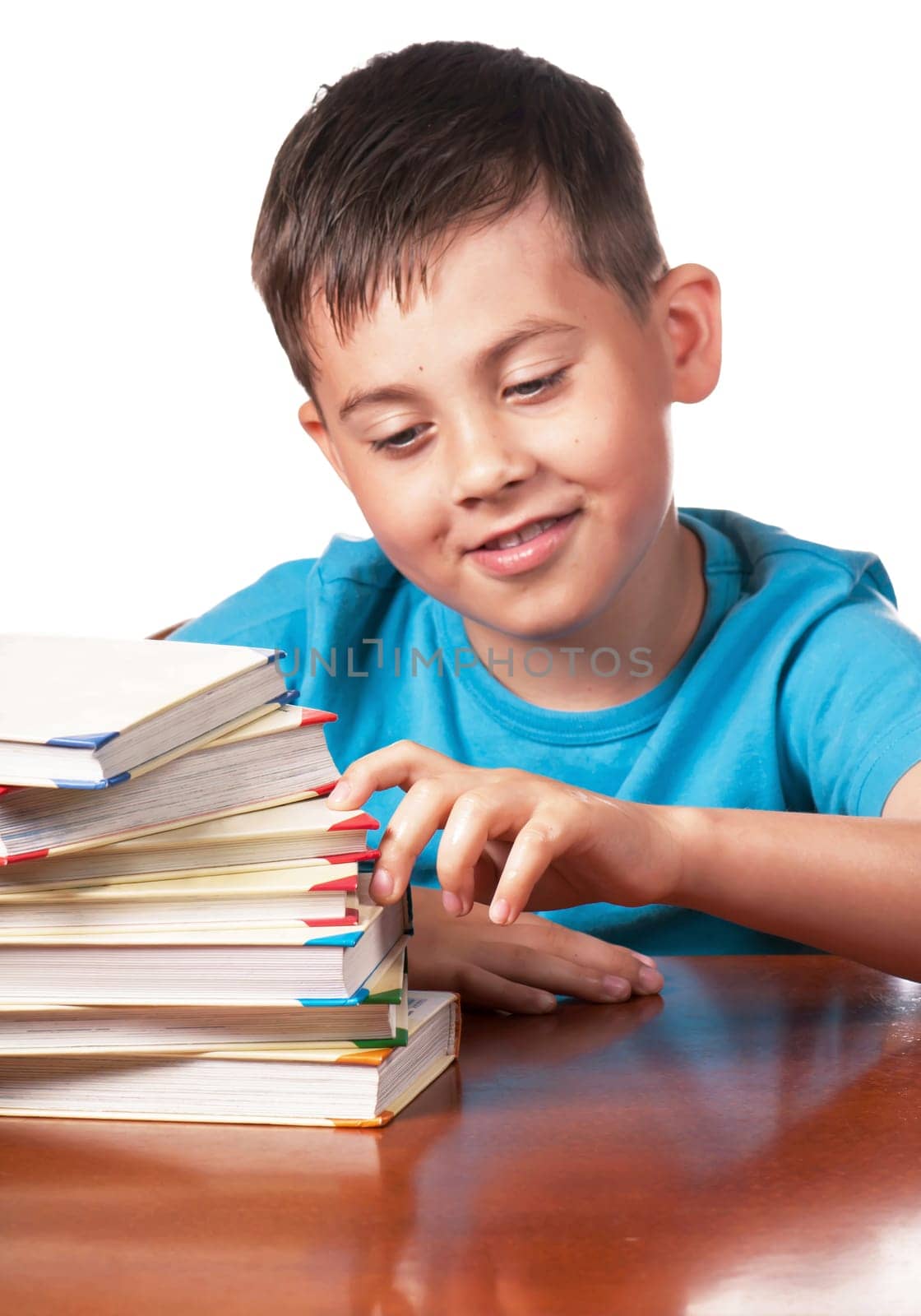 Child and books. The boy reads and plays with books. The kid steps up with his fingers on a pile of books. A preschooler is learning to read. Portrait of a boy on a white background by aprilphoto