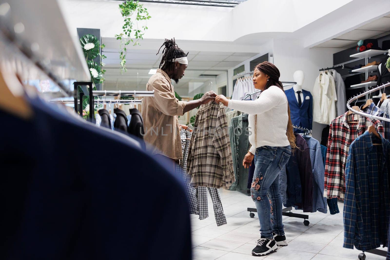 Customer getting help from girlfriend in choosing formal shirt by DCStudio