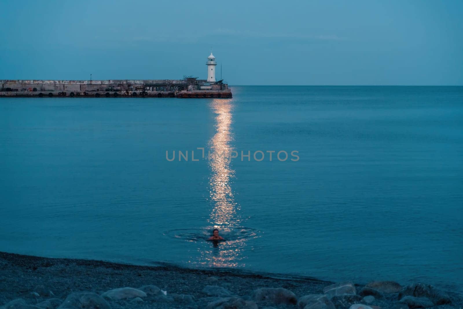 Woman The full moon rises to the lighthouse, the lunar path along the sea leads to the woman