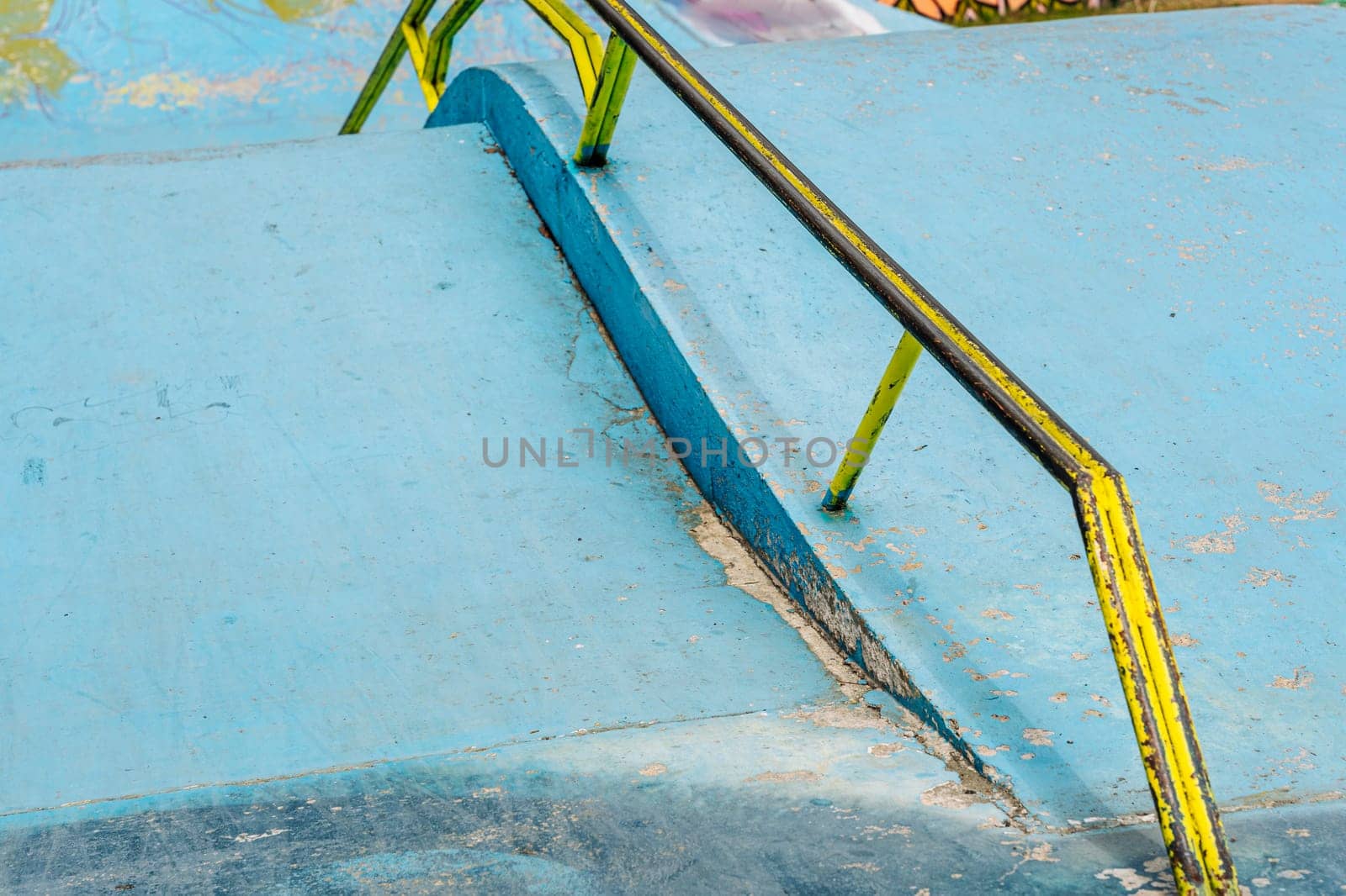 a ramp with an iron ramp for jumping in a skate park. concrete ramp for stunt scooters. The concept of a healthy lifestyle and sports leisure. extreme sports. Handrail in skate park