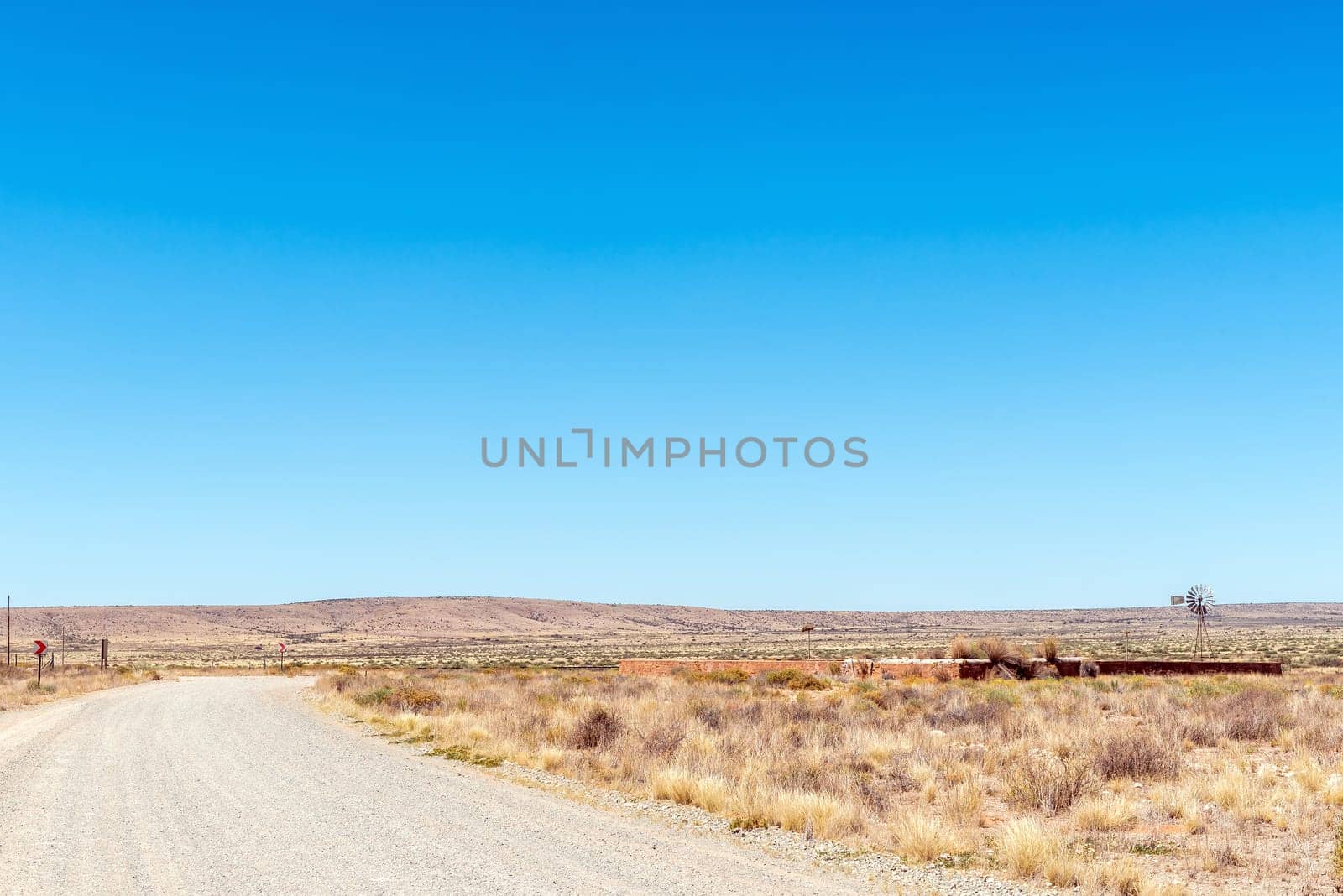 A road scene, with a stone livestock enclosure and windmill, at Putsonderwater. in the Northern Cape Province