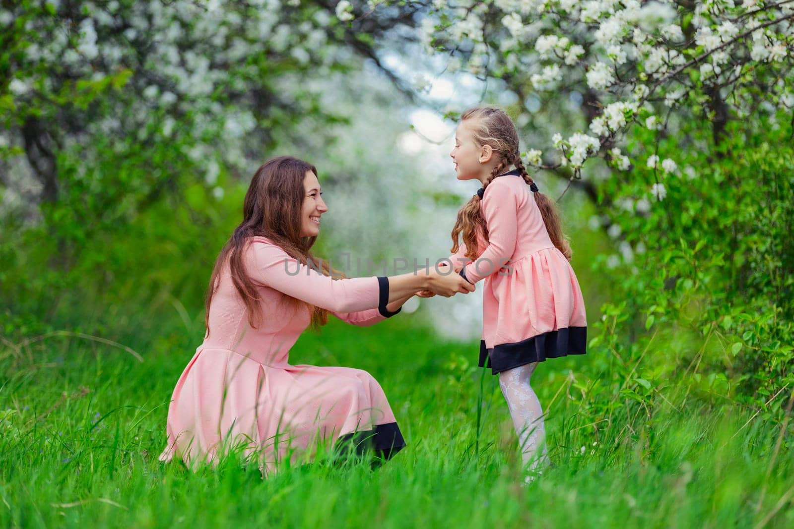 mother and daughter in nature in identical dresses