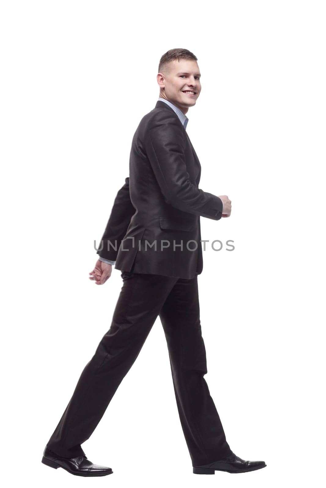 in full growth. young businessman confidently striding forward. isolated on a white background.