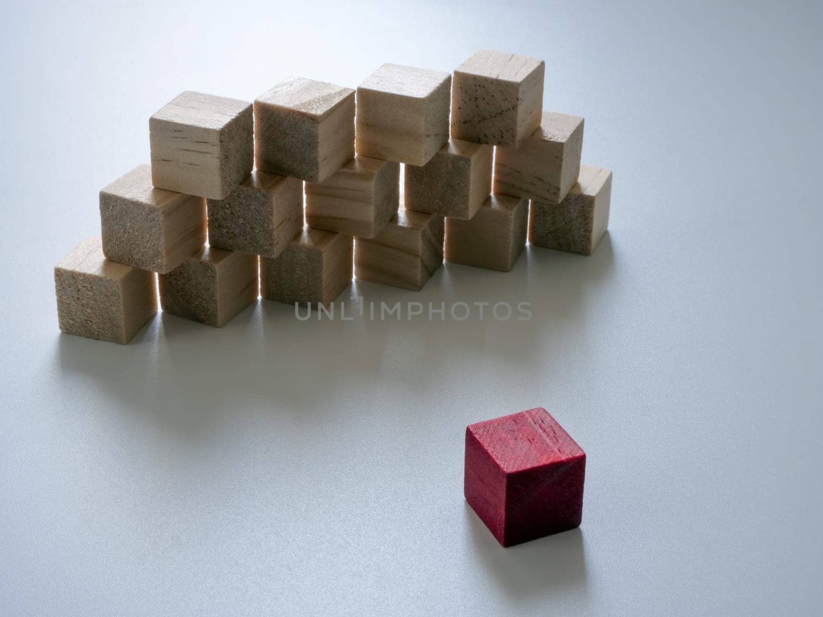 Wall of wooden cubes and in front of it is red. Overcoming difficulties and obstacles.