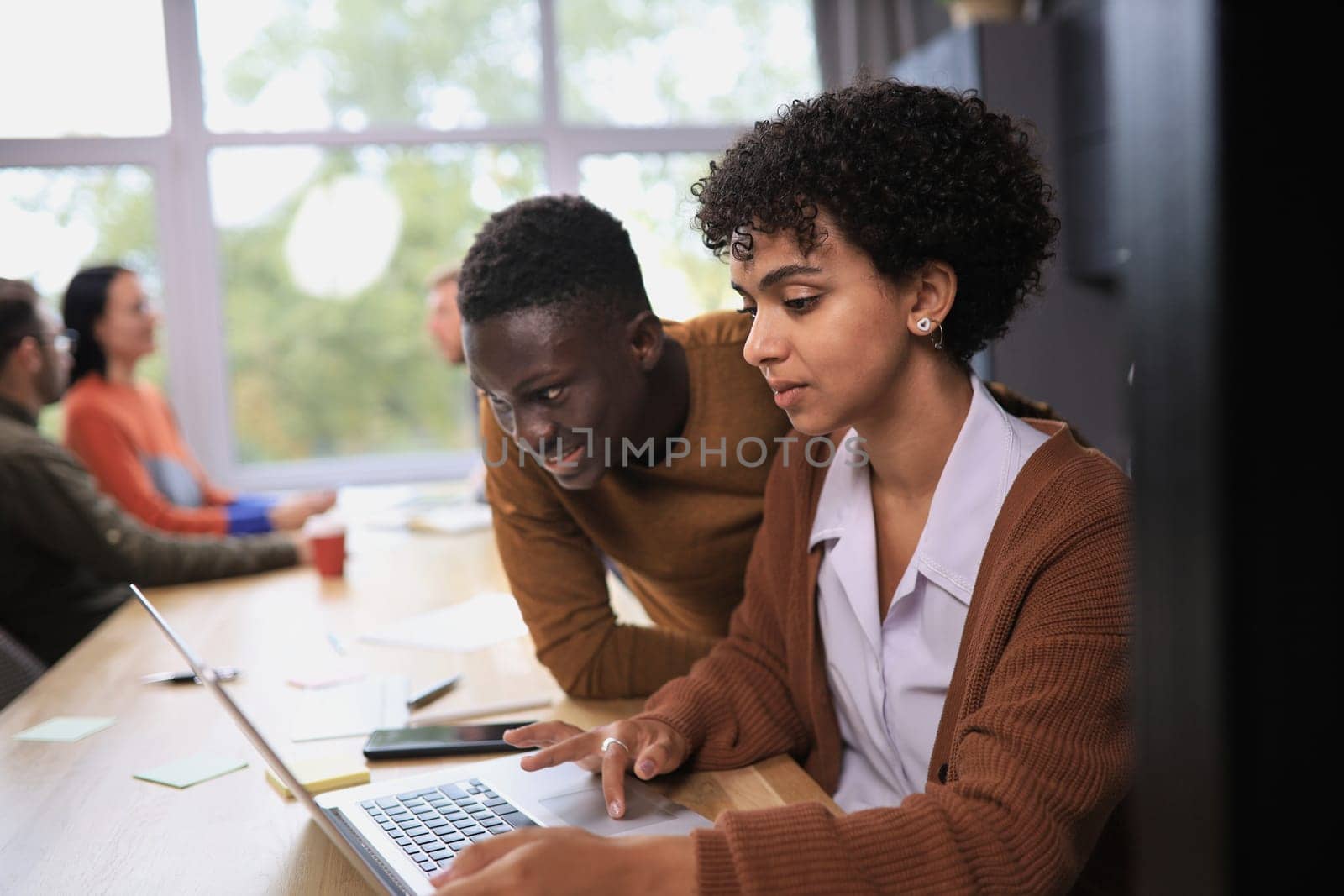 two professional businessmen discussing and using desktop computer in office by asdf