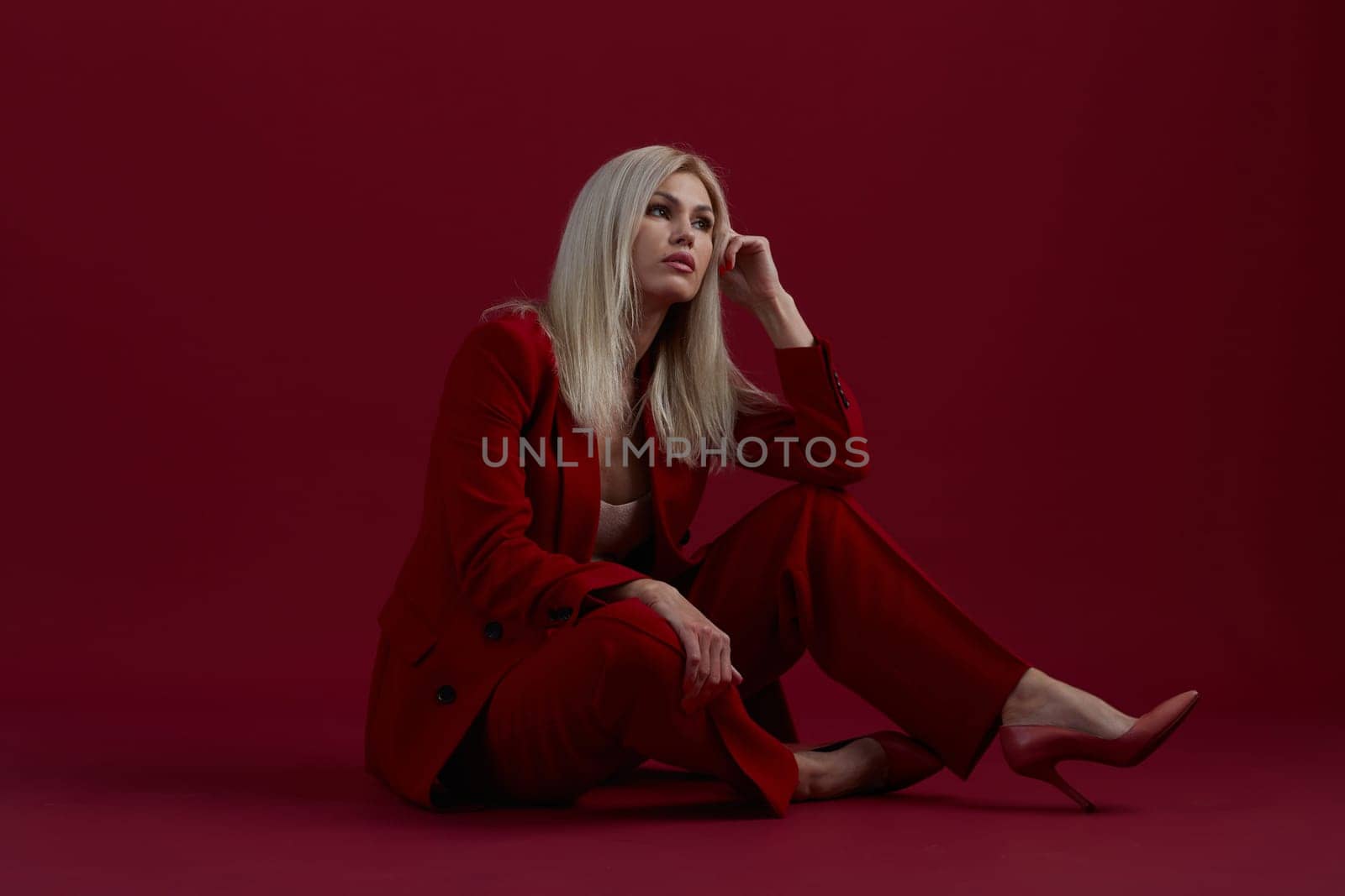 Fashion young woman in red suit. Red background. by asdf