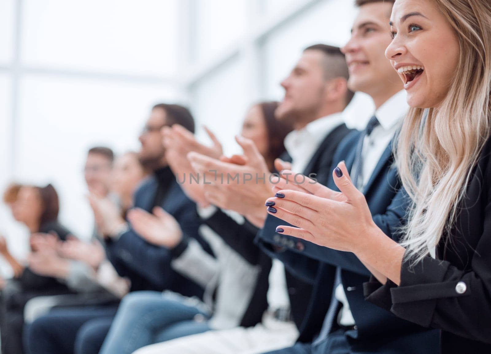 group of employees applauds during a business meeting by asdf