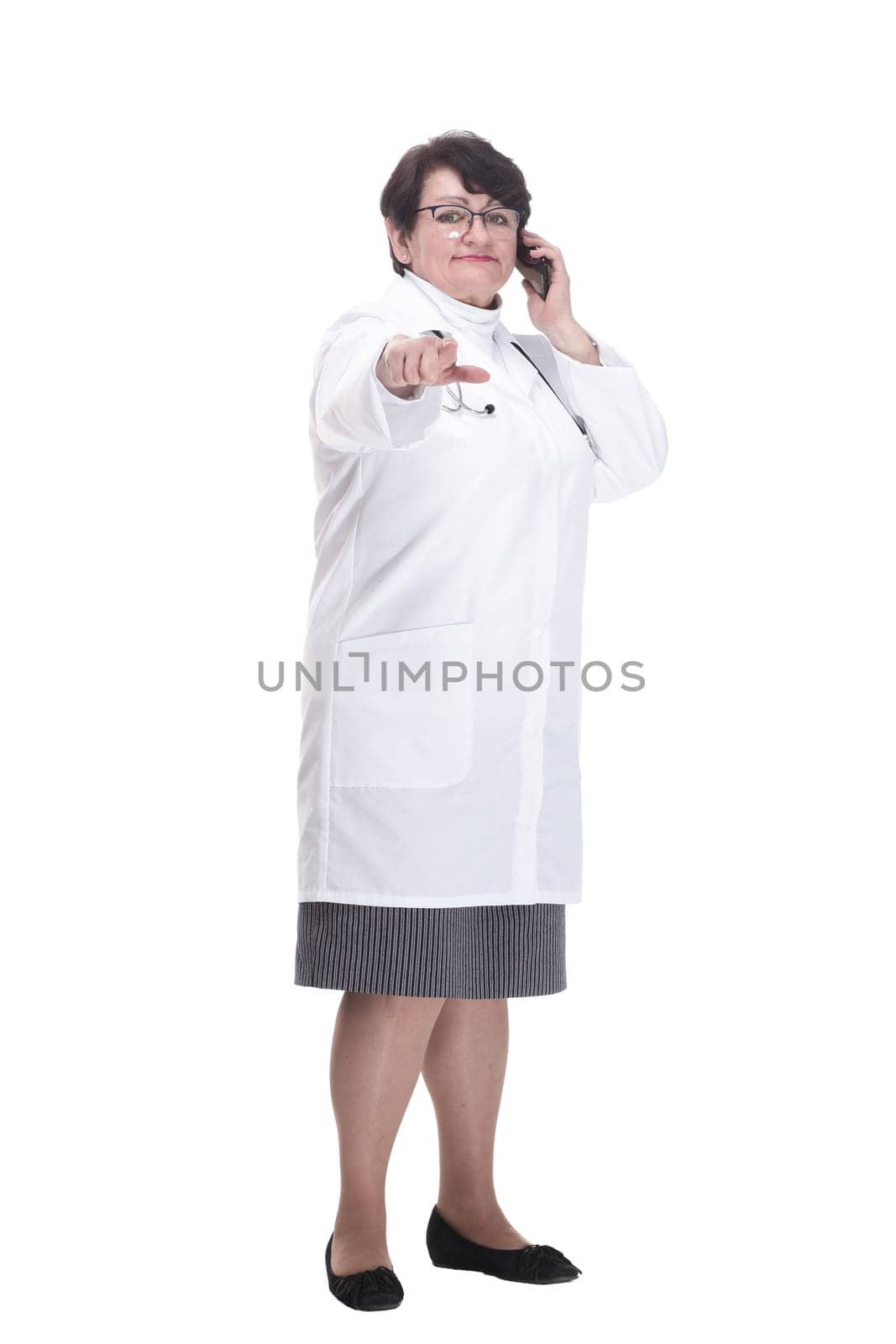 in full growth. senior female medic with a smartphone. isolated on a white background.