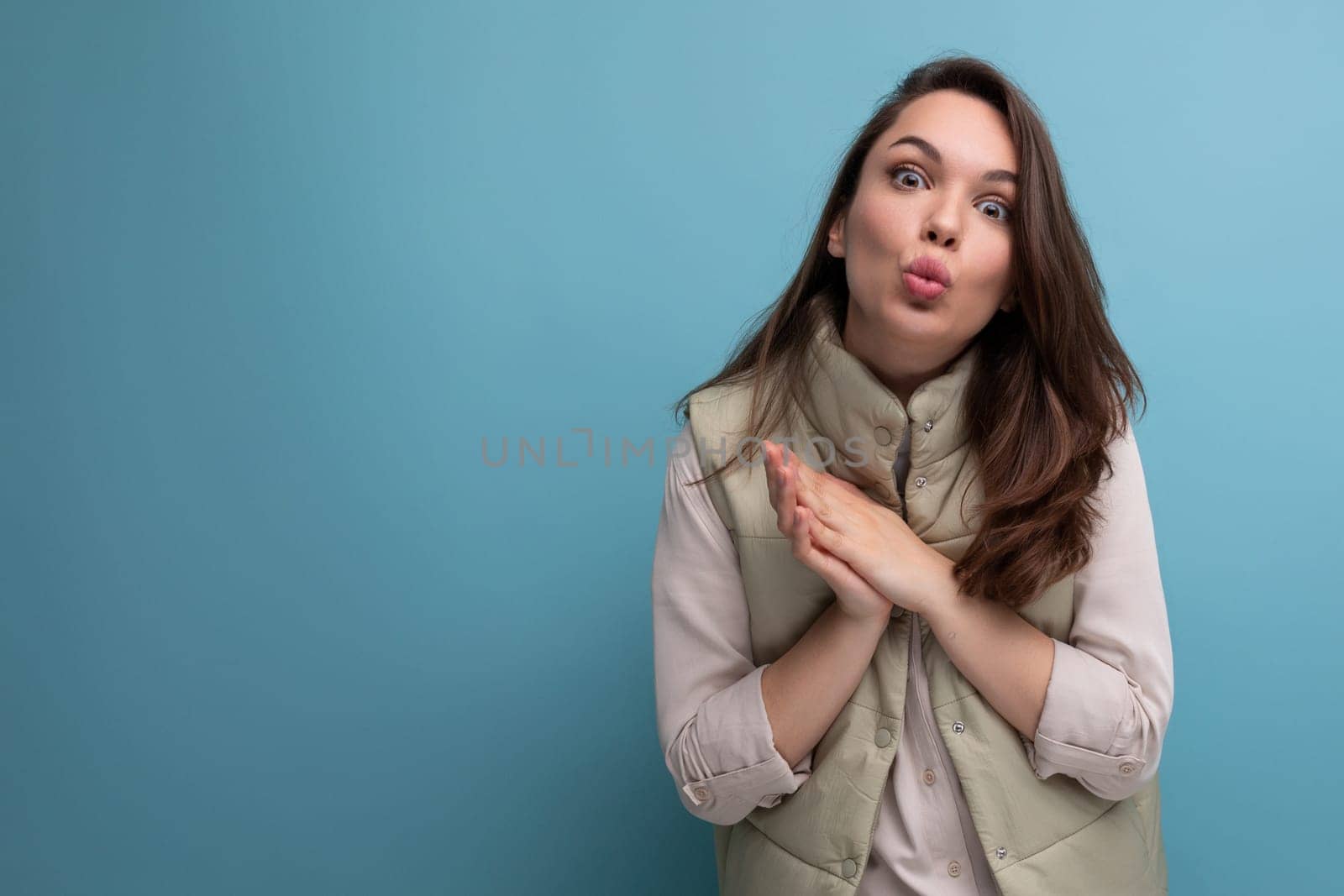 coquettish young brunette female adult in casual outfit flirting on studio background.