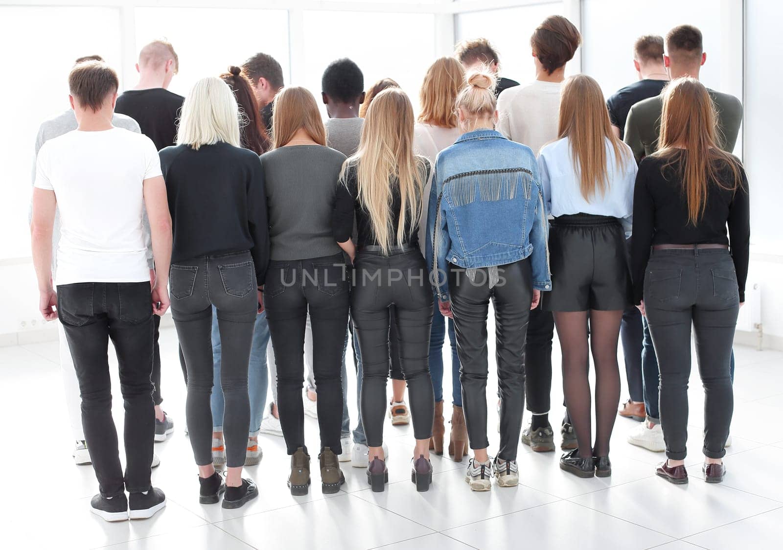 large group of young people looking at a large white screen by asdf