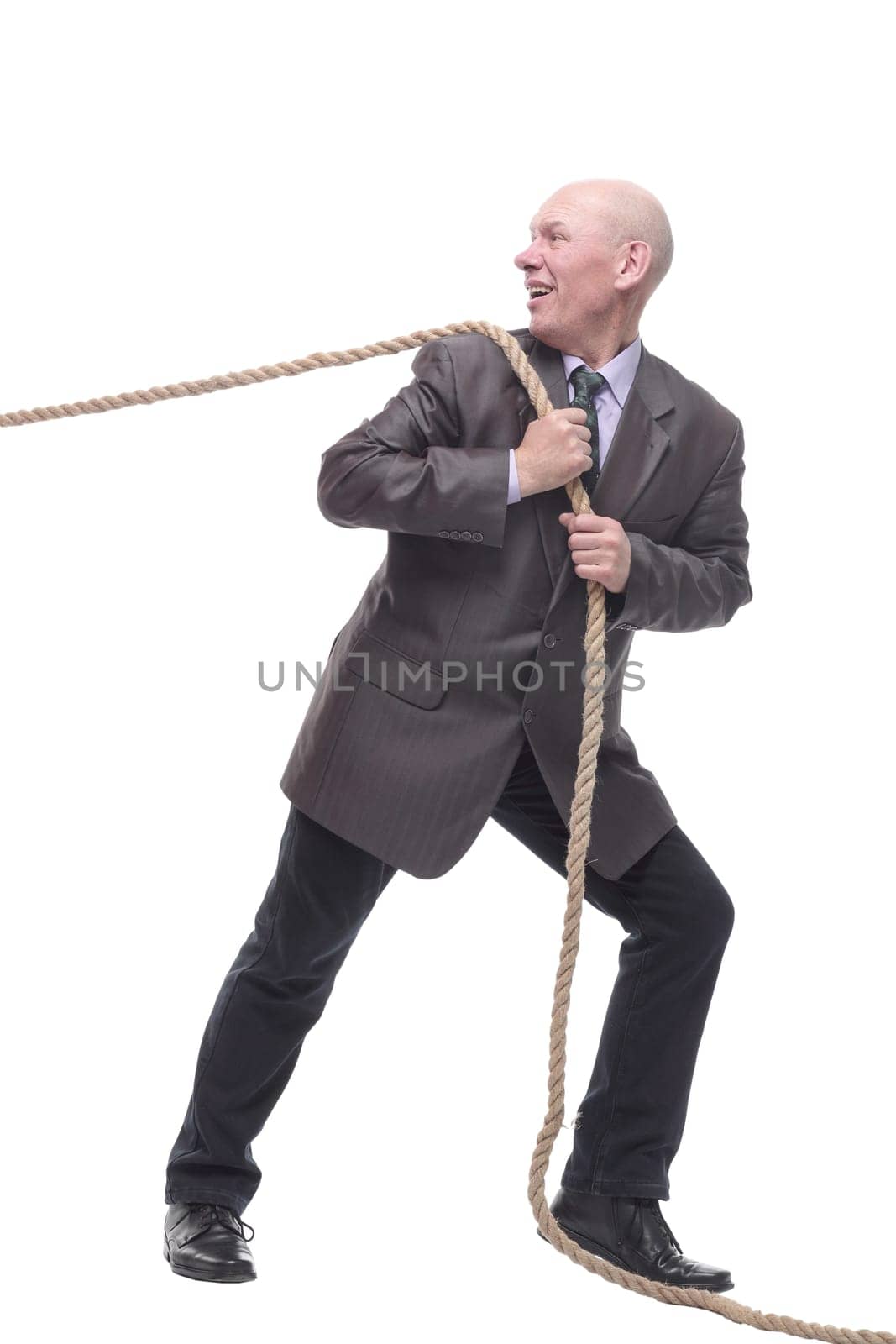 in full growth. business man pulls a rope. isolated on a white background.