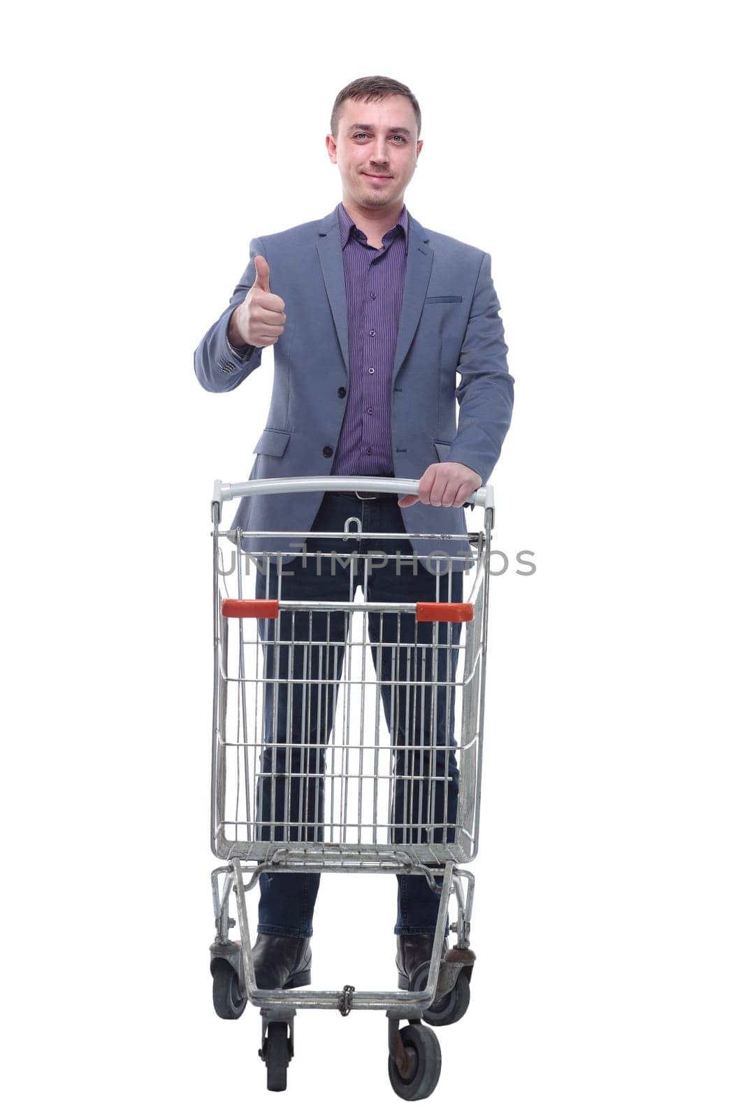A full length portrait of a man pushing an empty shopping cart isolated on white background