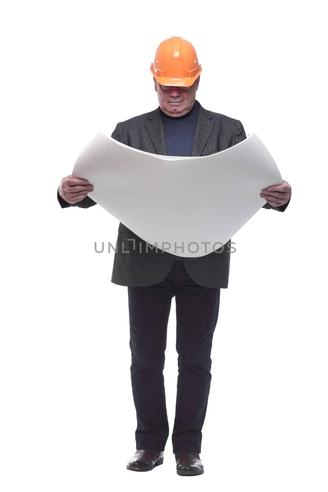 in full growth. architect in protective helmet reading drawing. isolated on a white background