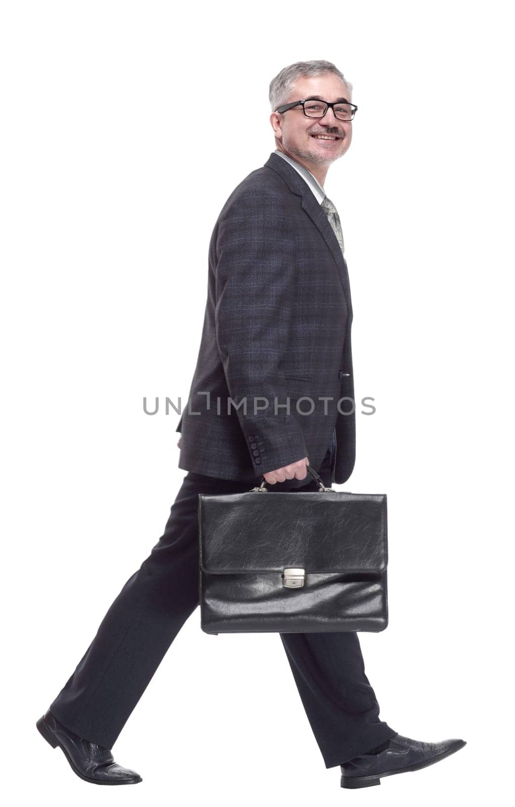 in full growth. confident man with briefcase striding forward. isolated on a white background