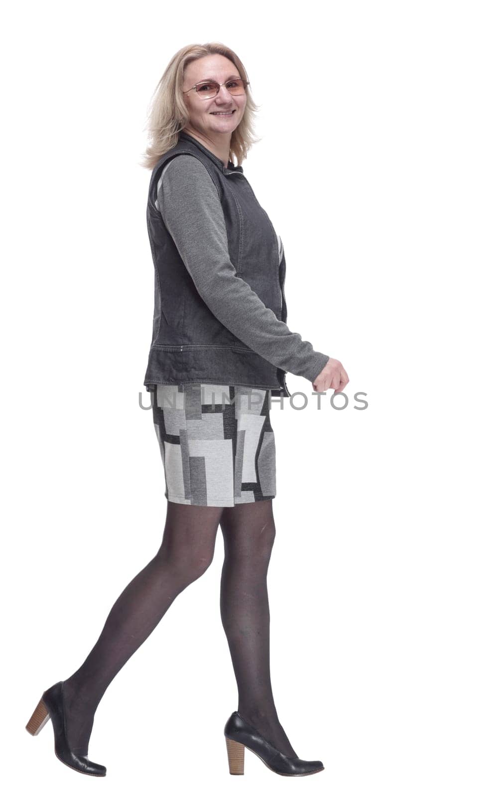 side view. confident young woman striding forward. isolated on a white background