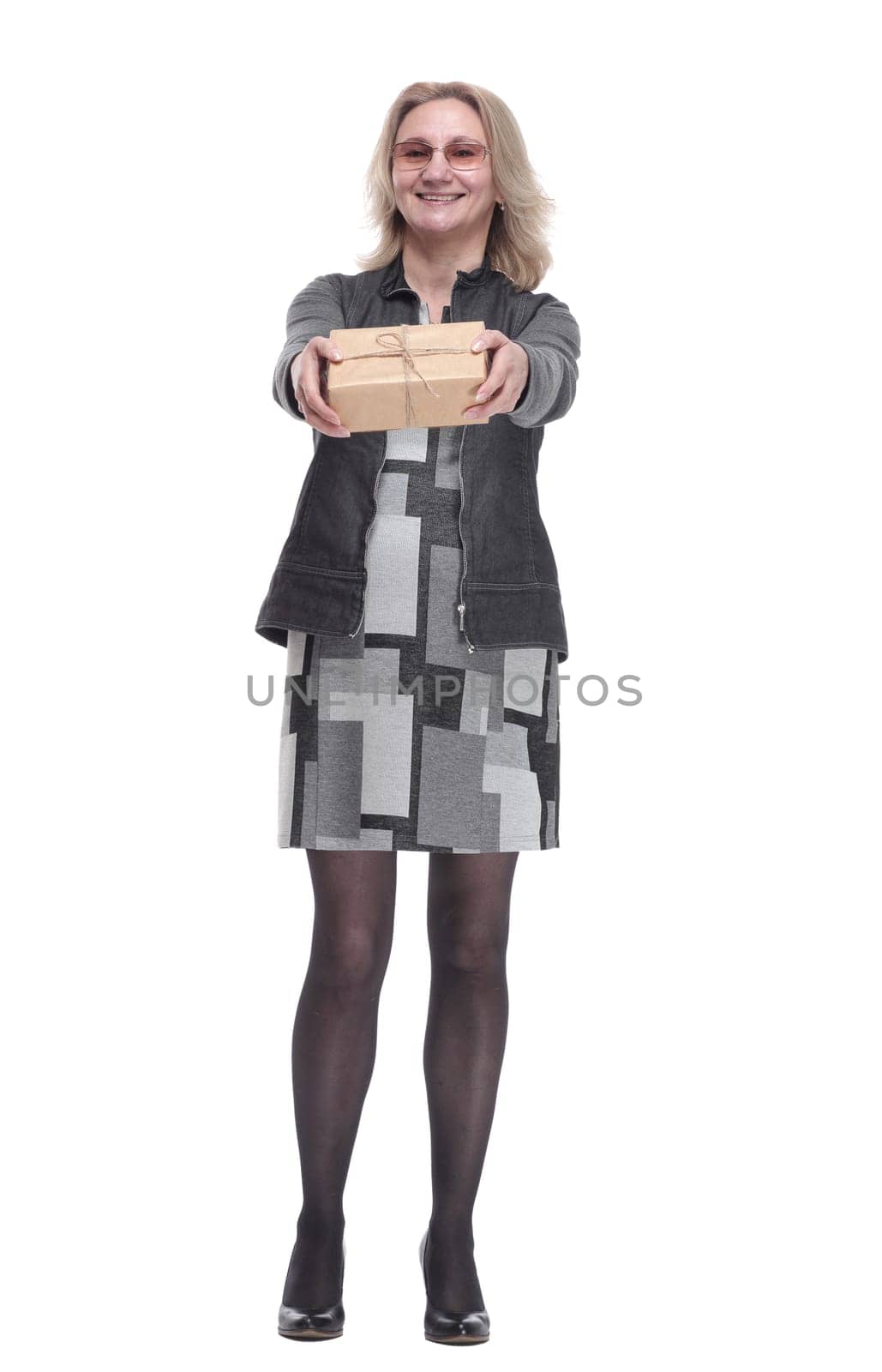 in full growth. happy young woman holding out a gift box. isolated on a white background