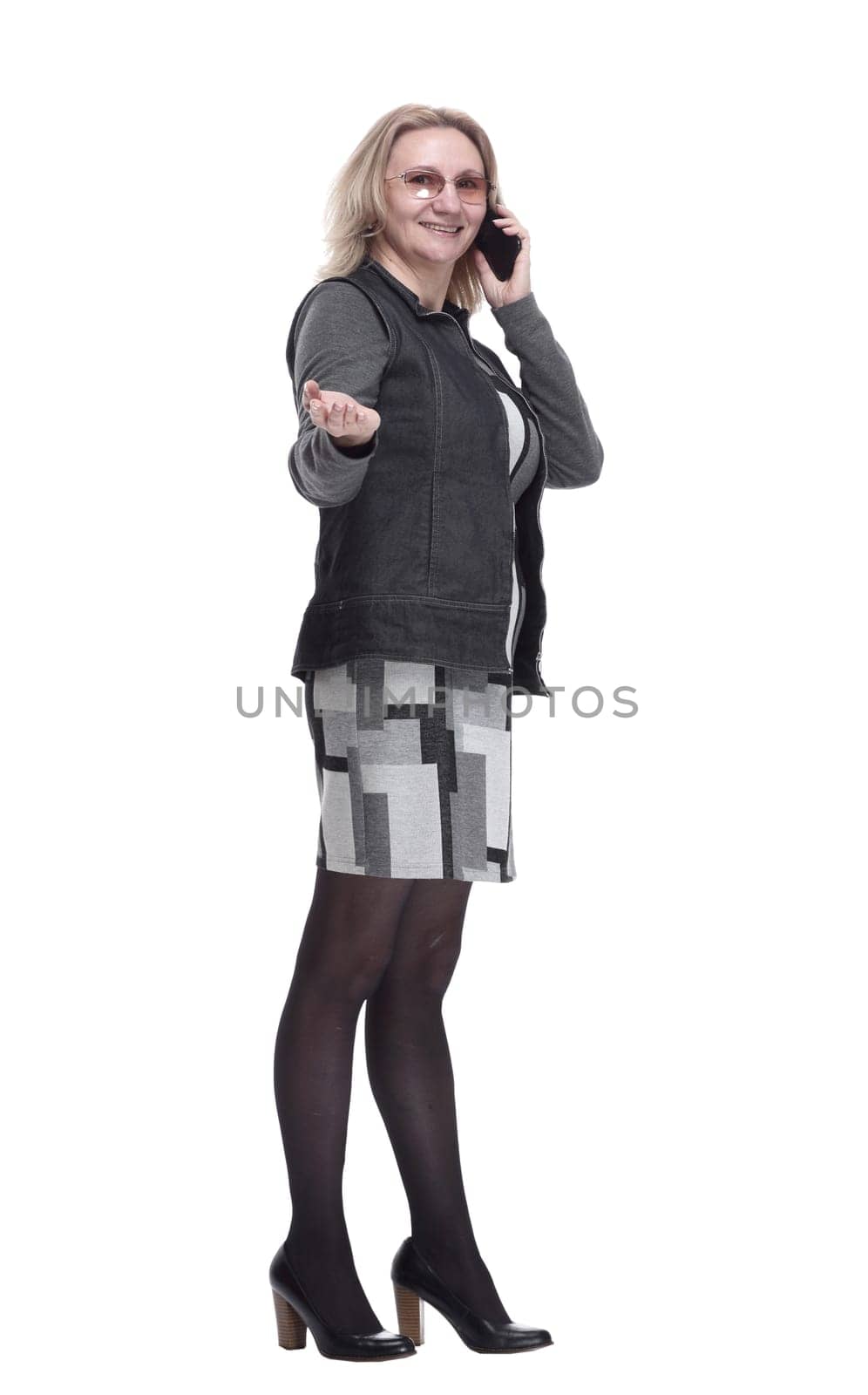 in full growth. a young woman with a smartphone reading an ad. isolated on a white background