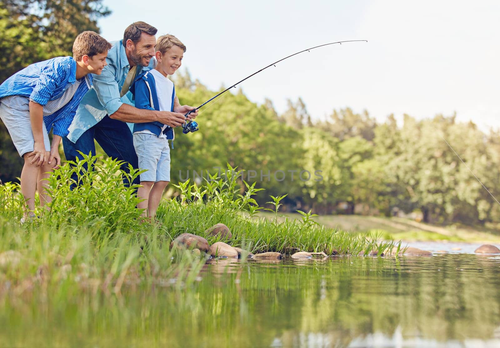 Fishing is a family activity. a father and his two sons out fishing in the woods. by YuriArcurs