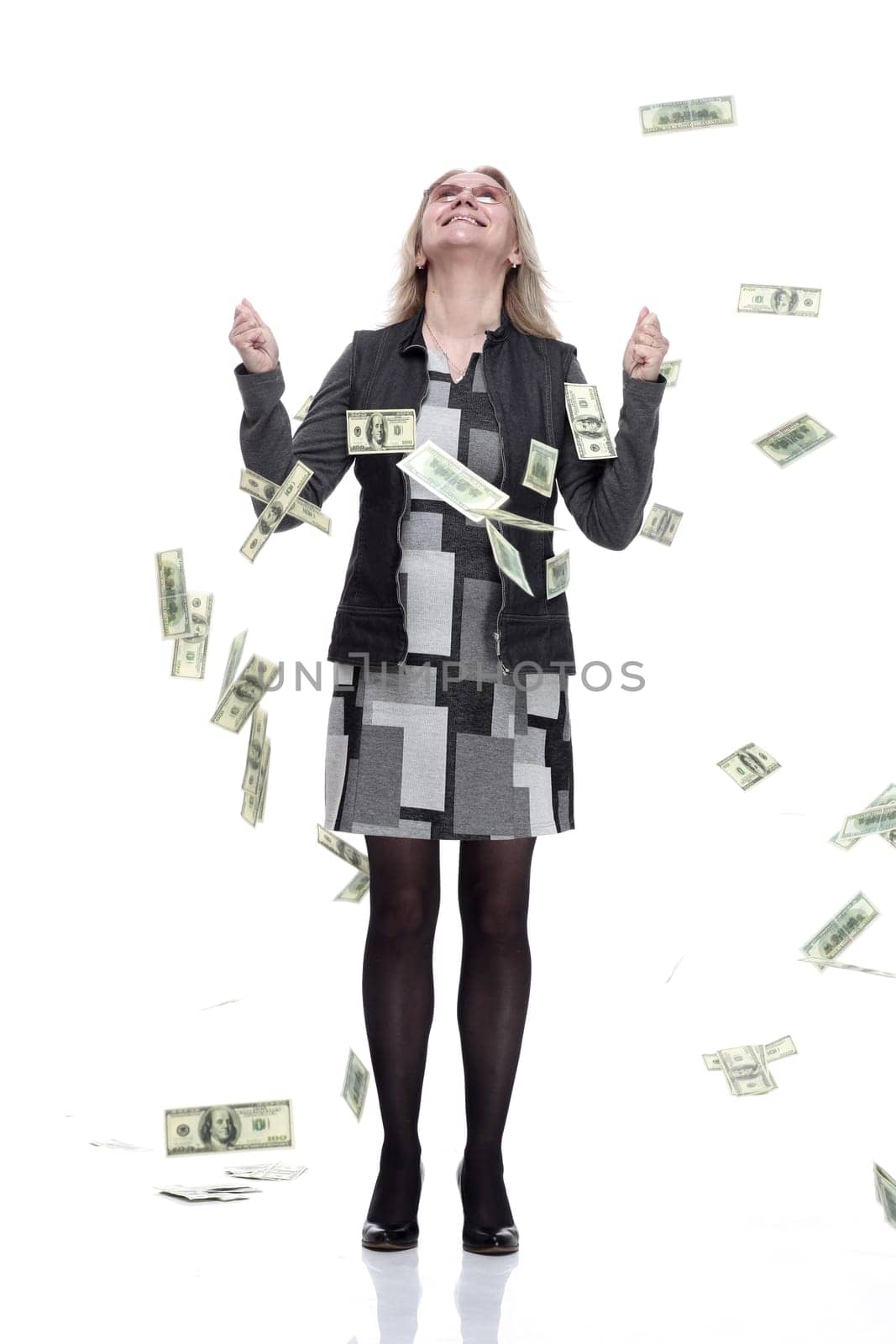 in full growth. happy young woman standing in the rain of money. isolated on a white