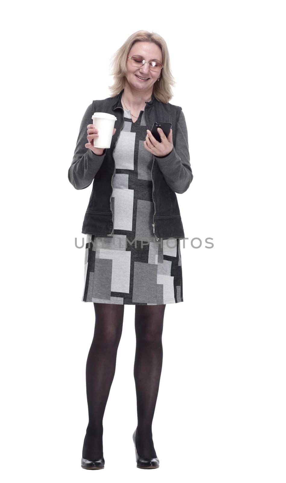 in full growth. casual a young woman with a smartphone drinks coffee to take away . isolated on a white