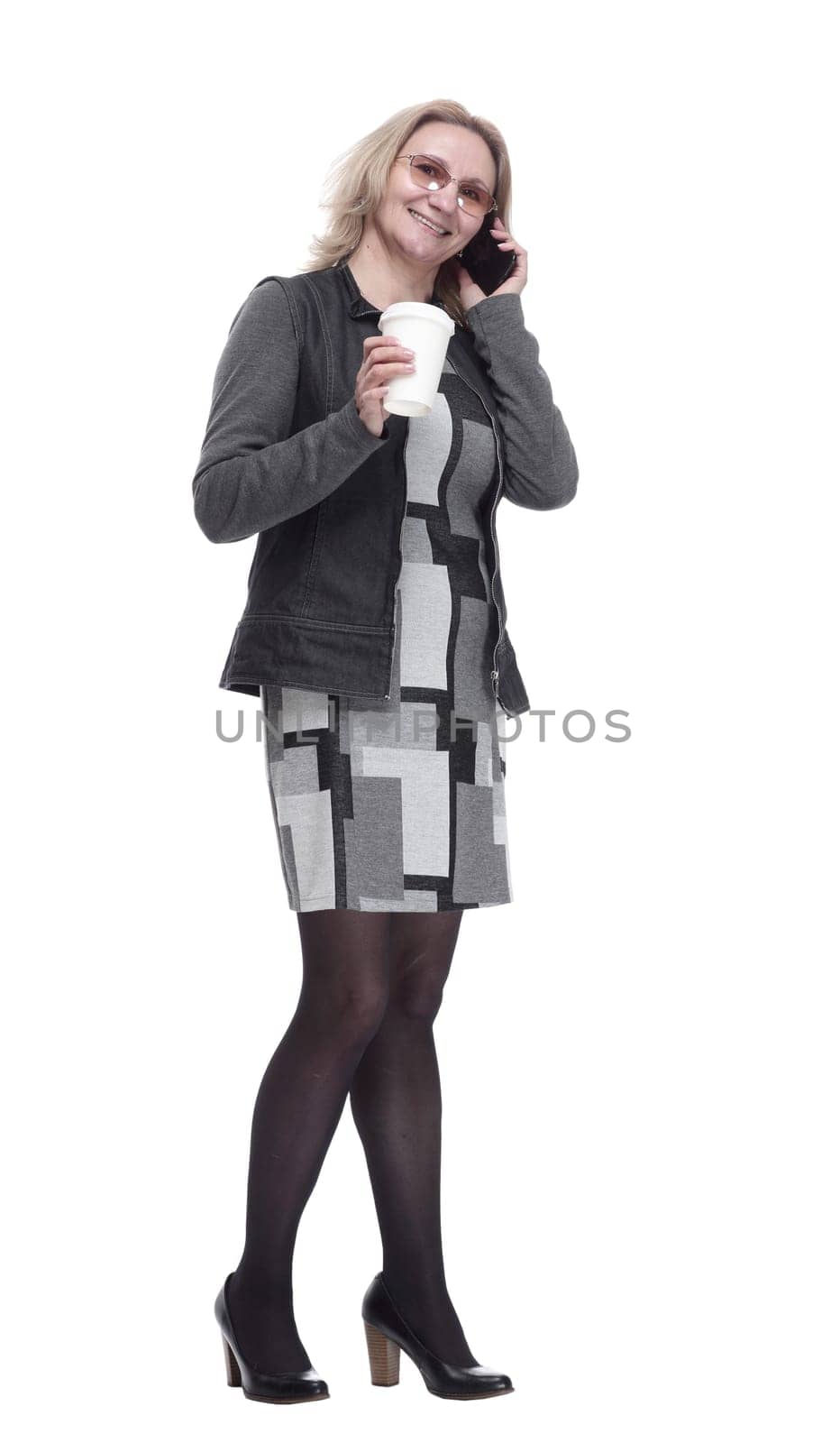 in full growth. a woman with a takeaway coffee talking on her smartphone . isolated on a white background