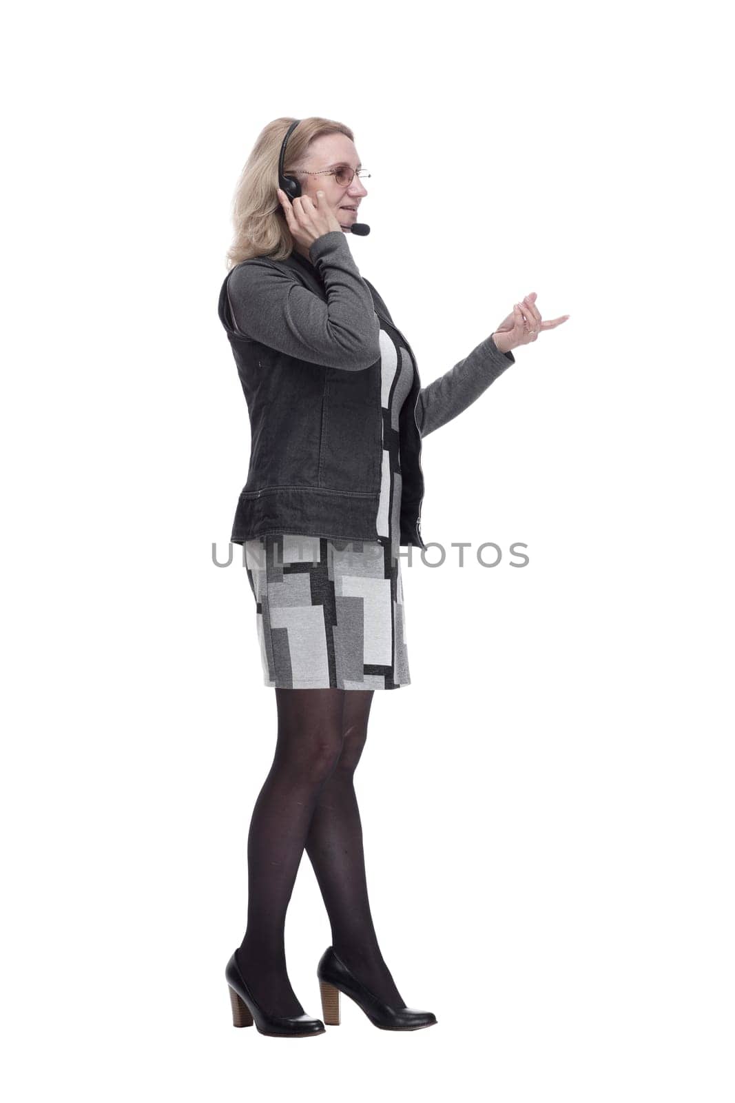 in full growth. an attractive woman in a headset looking at a white screen. isolated on a white