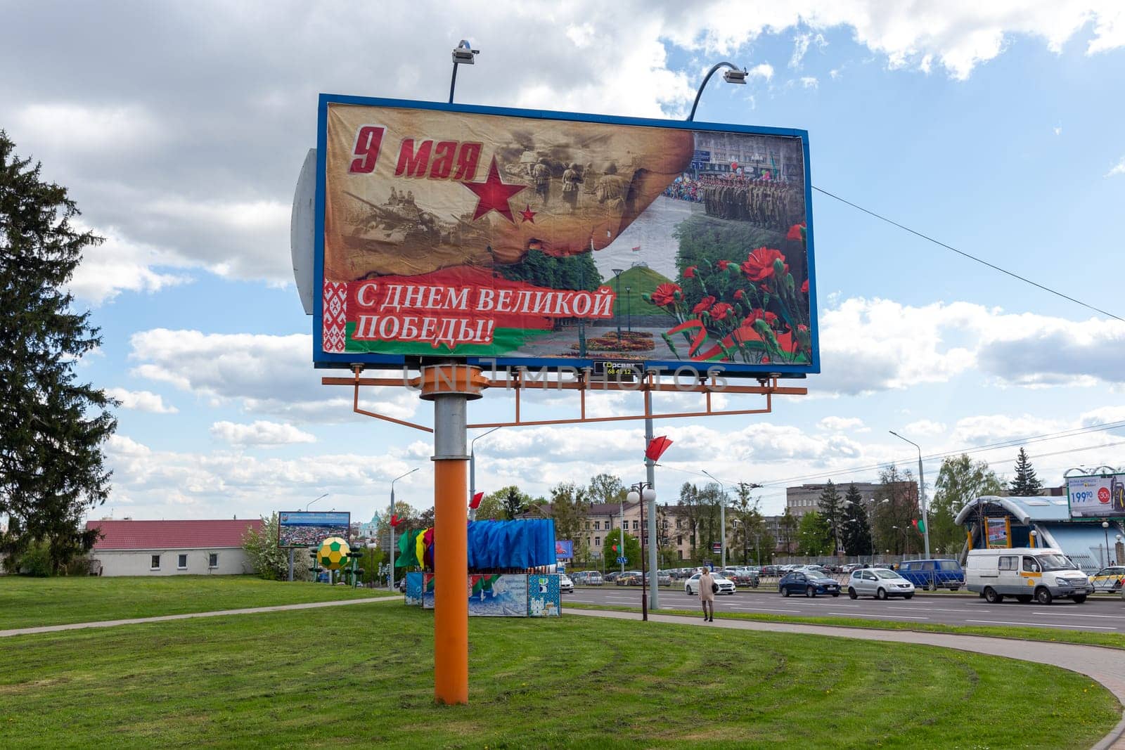 Grodno, Belarus - 24 April, 2023: A billboard with congratulations on Victory Day on May 9 which includes images of carnations, the Mound of Glory, the victory parade, military operations