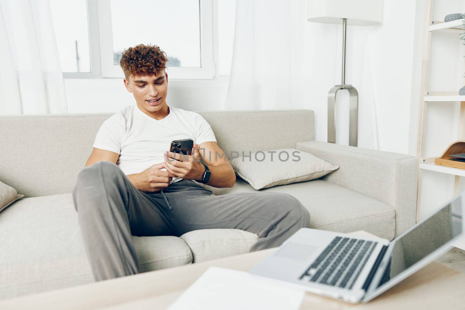 man interior young text cyberspace freelancer student internet smile lifestyle blogger text message sofa by SHOTPRIME