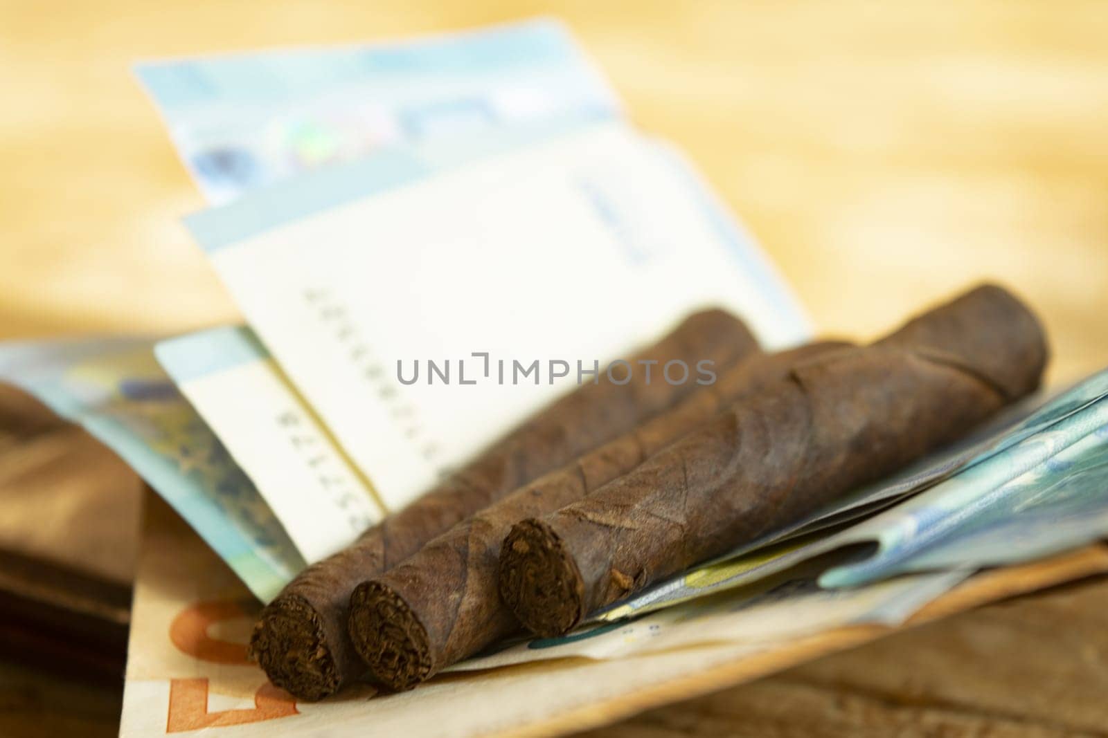 smoking costs concept with cigars leaning on banknotes