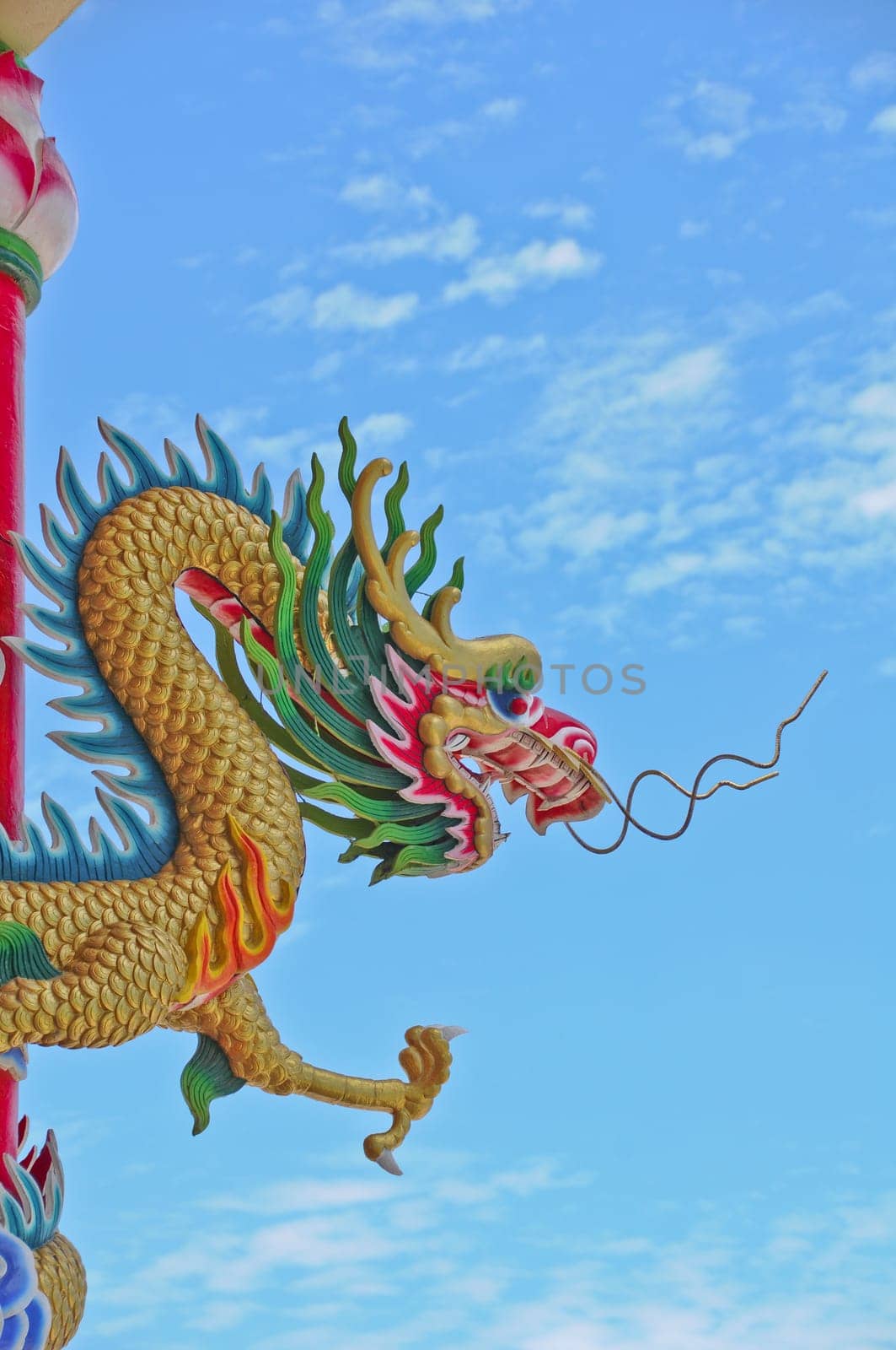 Golden flying majestic Asian Chinese dragon statue with blue sky in sunny day by eyeofpaul