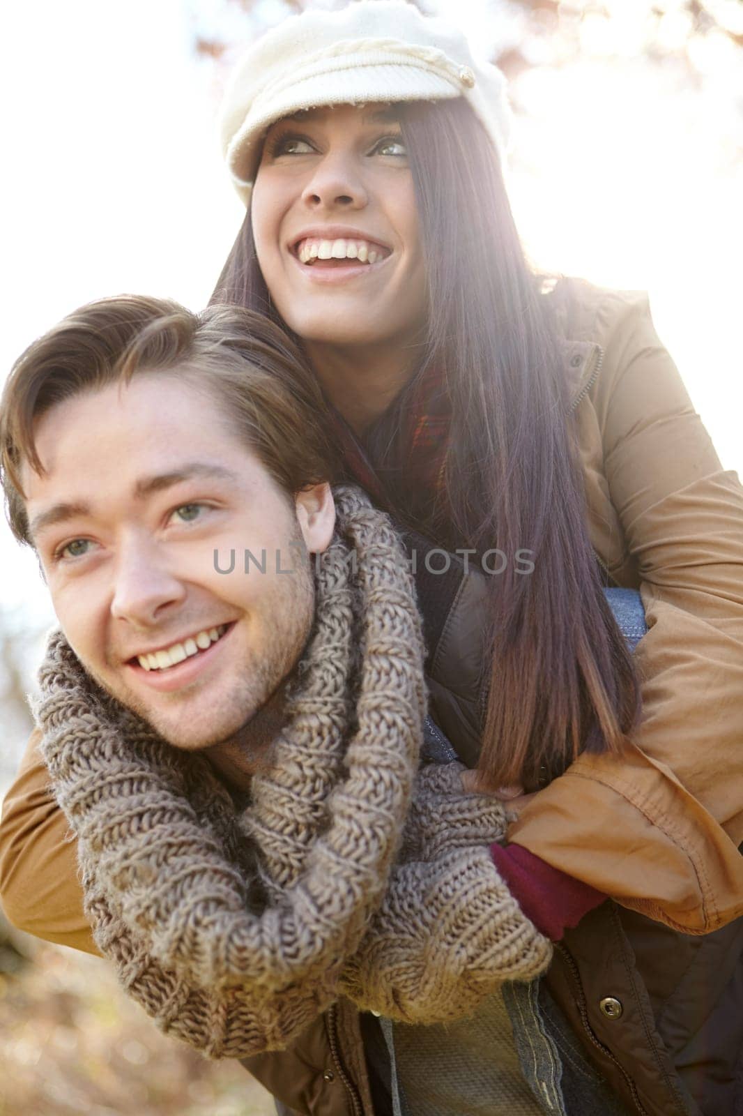 Having fun together. A young man piggybacking his girlfriend while outdoors in the woods