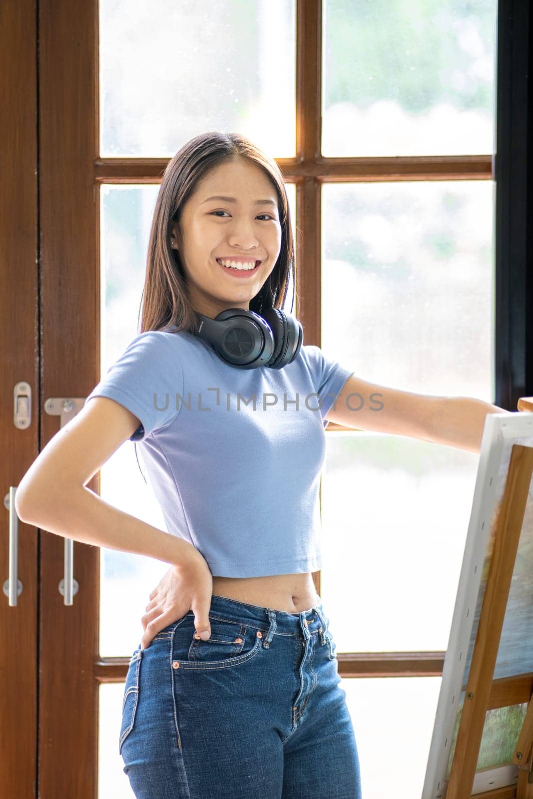 Young happy Asian woman chilling day off painting at home, female artist on canvas at home. hobby drawing. High quality photo