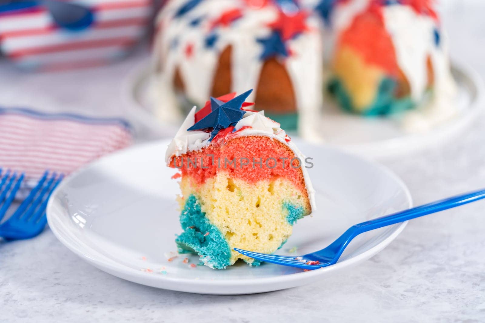 Slice of July 4th bundt cake covered with a vanilla glaze and decorated with chocolate stars.