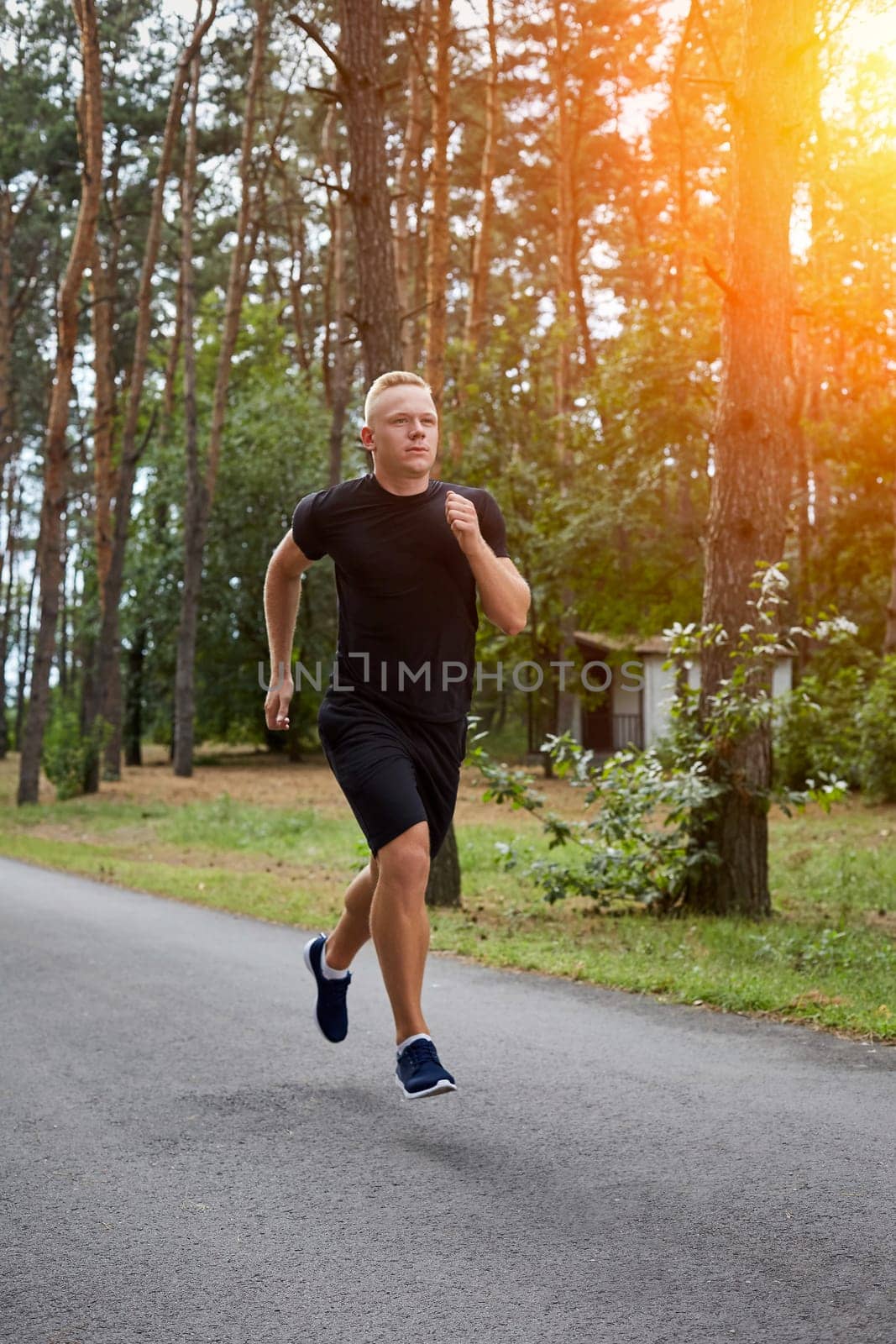 young athlete running in the forest, motion blur. with a sun flare