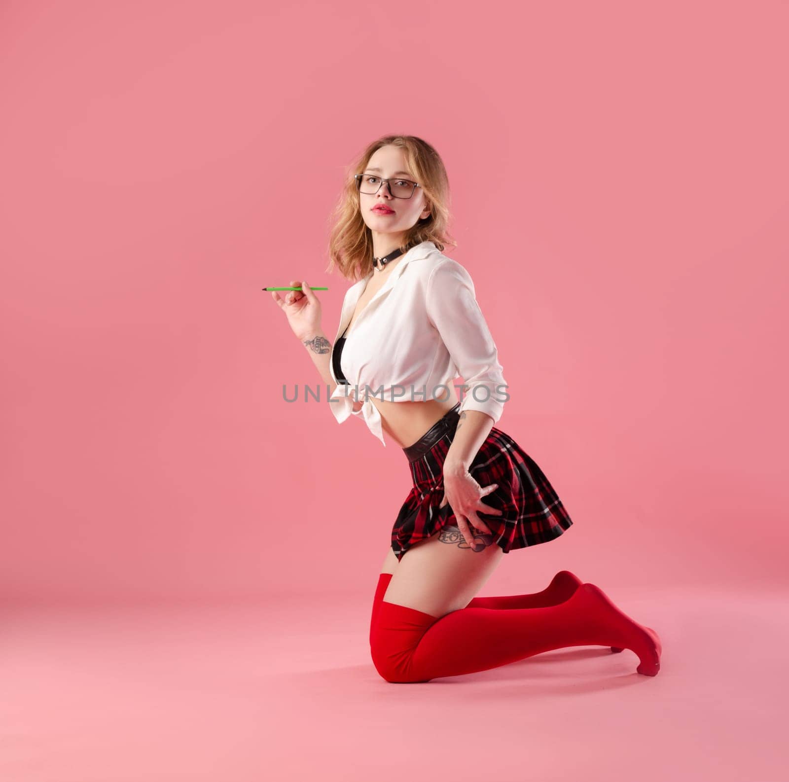 sexy girl sexy schoolgirl costume with glasses on pink background copy paste