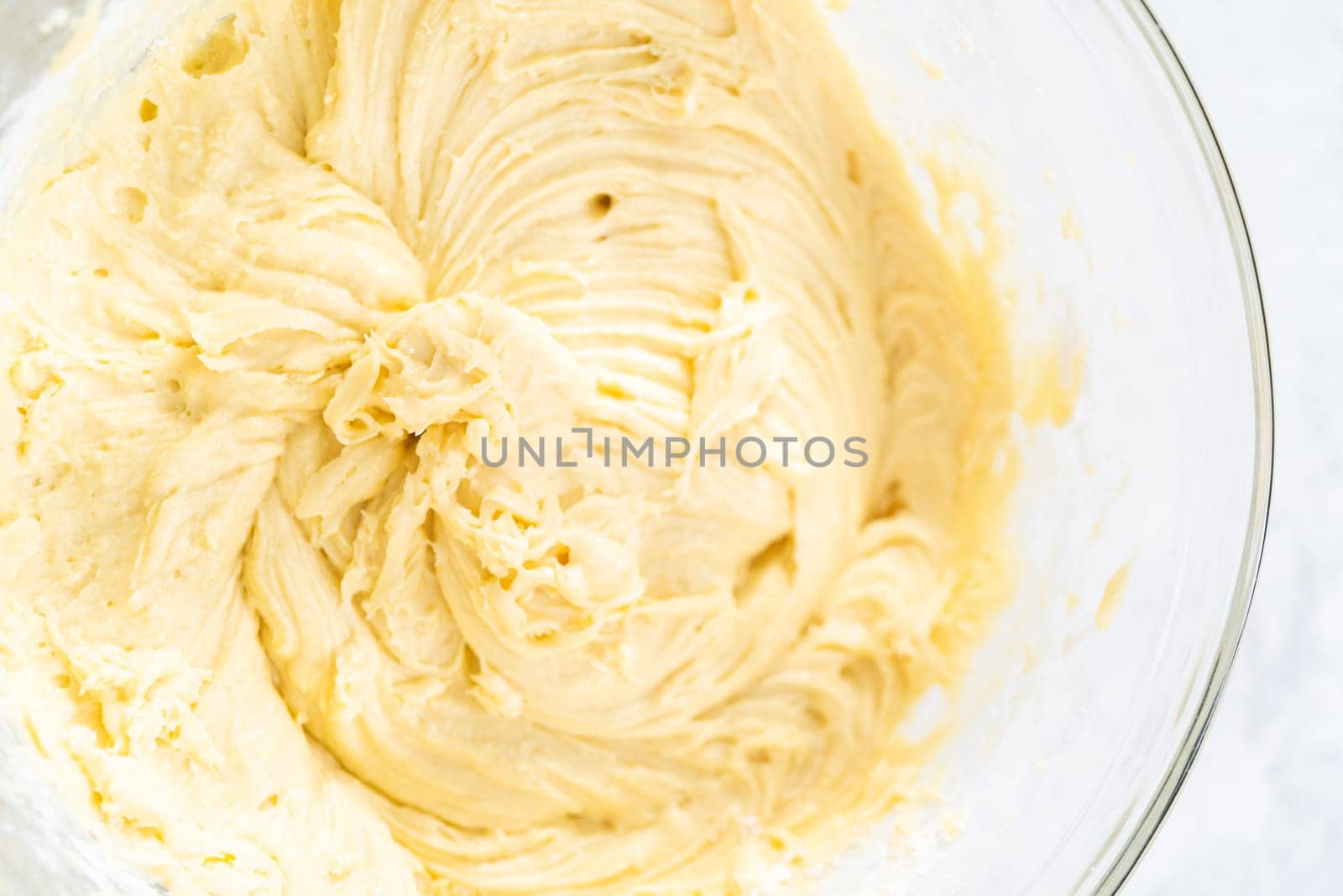 Mixing ingredients in a glass mixing bowl to bake July 4th bundt cake with chocolate stars.