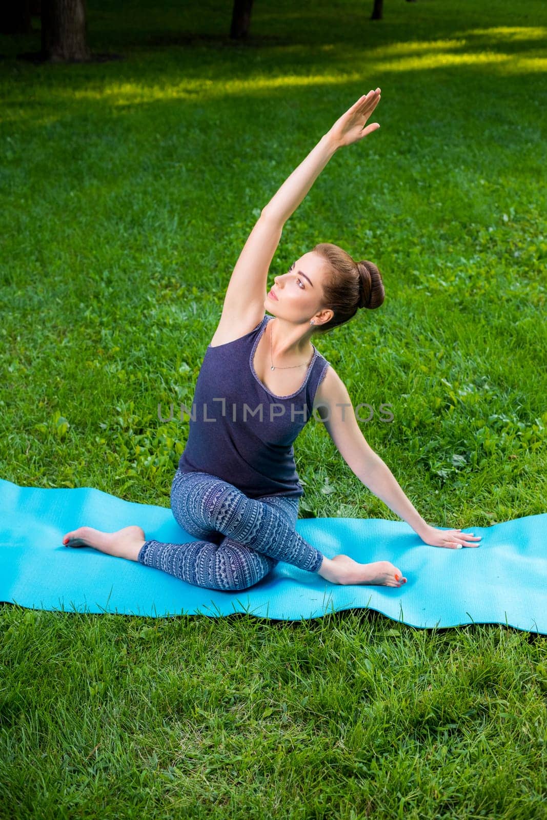 Young fitness woman meditation in a city park.Yoga at sunset in the park. Girl is practicing yoga. Fitness training outdoors. Attractive fitness woman. Workout outdoors. Healthy lifestyle