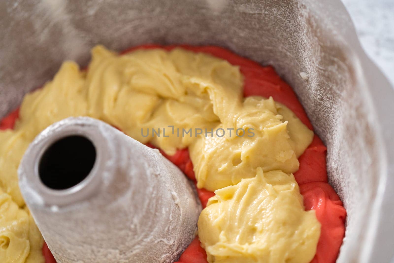 Filling bundt cake pan with red, white, and blue cake dought to bake July 4th bundt cake with chocolate stars.